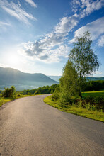 Country Road Down The Hill. Beautiful Travel Background. Sunny Morning Weather In Mountains. Trees Along The Path