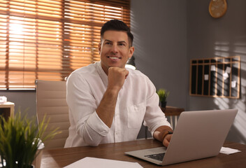 Wall Mural - Freelancer working on laptop at table indoors