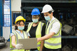 © Chaiya - Men and woman work together, wear safety facemask and using laptop. Caucasian engineer men, black woman, Asian woman wear facemask and using laptop in factory-warehouse
