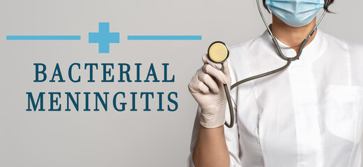 Wall Mural - Bacterial Meningitis - concept of text on gray background. Nearby is a cropped view of doctor with stethoscope