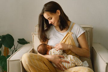 Wall Mural - newborn baby boy sucking milk from mothers breast. portrait of mom and breastfeeding baby.