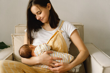 Wall Mural - newborn baby boy sucking milk from mothers breast. portrait of mom and breastfeeding baby.