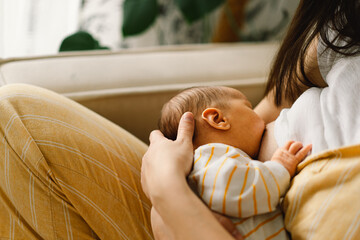 Wall Mural - newborn baby boy sucking milk from mothers breast. portrait of mom and breastfeeding baby.
