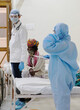 Vertical shot of a doctor and nurse in a medical uniform standing near a patient in a hospital