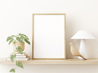 Poster - Small vertical wooden frame mockup in japandi style interior with trailing green plant in pot, lamp, books and shelf on empty warm white wall background. A4, A3 format. 3d rendering, illustration