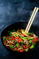 Wall Mural - Rice noodles with vegetable stir fry on the ceramic plate on dark background