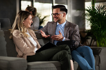 Wall Mural - Colleagues talking in the office. Businesswoman and businessman discussing work in office..