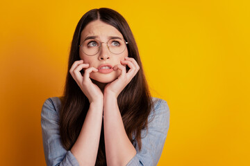 Wall Mural - Photo of afraid girlfriend driven mad look up empty space isolated yellow color background