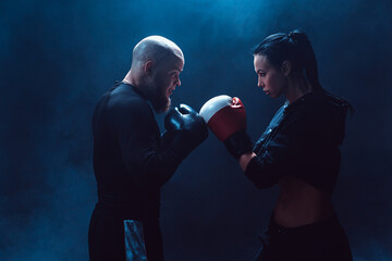 Wall Mural - Woman exercising with trainer at boxing and self defense lesson,