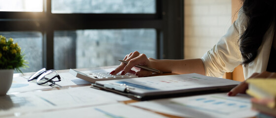 Close up a accountant working about financial with calculator at office to calculate expenses, Accounting concept