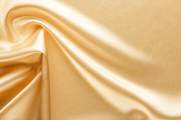 Wall Mural - bright shiny golden fabric draped with large folds, textile background
