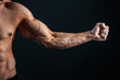 © zamuruev - tense arm clenched into fist, veins, bodybuilder muscles on a dark background, isolate