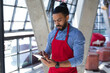 © Wavebreak Media - Mixed race male barista in apron using tablet in cafe