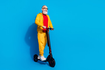 Sticker - Full length profile portrait of cheerful person look empty space driving moped isolated on blue color background