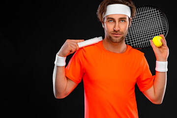 Wall Mural - Tennis player with racket in orange t-shirt. Man athlete playing isolated on black background.