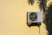 Air Conditioner Compressor Near Palm Leaf Shadow.