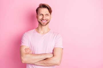 Photo of confident pretty gentleman dressed casual t-shirt arms crossed smiling looking empty space isolated pink color background