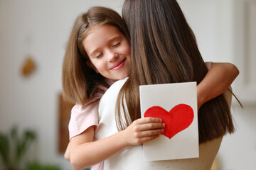 Wall Mural - Happy daughter with greeting card hugging mother