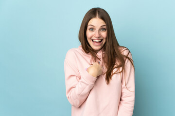 Wall Mural - Young caucasian woman isolated on blue background with surprise facial expression