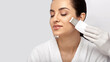 © Peakstock - Beautiful woman's face during ultrasonic peeling skin procedure, close-up. Cleansing facial skin, remove blackheads, isolated on gray