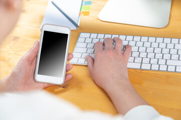 woman hands close up working on white computer keyboard and smartphone, work from home concept. work online, shopping