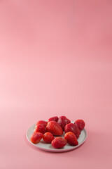 Delicious juicy ripe red strawberries on a pink background. Close-up shot of strawberries on a grater. Macro shot of garden strawberry