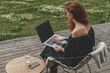 © Epic_pic - Back view of business woman working with laptop and sitting outdoor in a beautiful terrace in forest