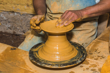 Mexican potter craftsman, working the clay with his hands in his workshop to create sculptures, vases, jugs, vases etc, using traditional methods.