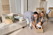 © insta_photos - Overjoyed excited happy householders renters tenants parents moving pushing carton box with kid, riding in box in new living room apartment, having fun in their first real estate property.