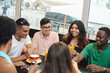 © etonastenka - Multiracial happy young people drink coffee at cafe, black and white cheerful mates laughing enjoying drinks having fun sitting together at restaurant table, diverse friends share lunch at meeting