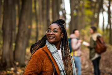 Three female friends having fun and enjoying hiking in forest.