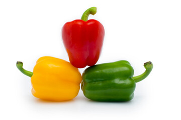 red, yellow and green peppers isolated on white