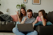 Overjoyed family sit relax on couch at home feel euphoric win online lottery on laptop.