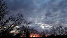 Time Lapse Video Of The Dramatic Sky At Sunset With Clouds And The Setting Sun Over The City Skyline. 16x9 Video High Quality. ProRes 422 HQ.