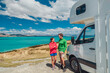 © Maridav - RV motorhome camper van road trip on New Zealand. Young couple on travel vacation adventure. Two tourists looking at Lake Pukaki and mountains on pit stop next to their rental car