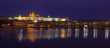 Prague Skyline Panorama At Night With Charles Bridge, Hradcany Castle And Saint Vitus Cathedral, Czech Republic.