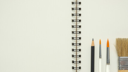 Wall Mural - open blank spiral notebook with paintbrush and black pencil , empty space for your text, top view of