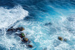 crushing sea waves texture. beautiful nature background view from above. unbelievable blue color of water. few rocks among foam