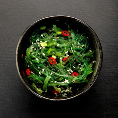 Wall Mural - Wakame seaweed with sesame and chilli on gray background. Asian food concept.