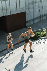 Wall Mural - Sportive couple during workout stair running outdoors