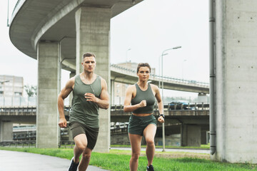 Wall Mural - Sportive couple during jogging workout on city street