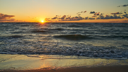 Wall Mural - Sonnenuntergang am Meer mit Wellen im Wasser