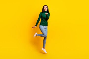 Sticker - Full size photo of nice optimistic brunette lady jump blow kiss wear green sweater jeans sneakers isolated on bright yellow color background