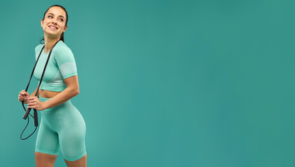 Wall Mural - Website header of Cheerful young woman in sportswear holding skipping rope