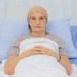 © Bangkok Click Studio - A middle-aged breast cancer patient lay on the bed and looking to camera with strong feeling eyes