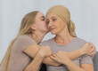 © Bangkok Click Studio - A young and beautiful daughter kiss her mother cancer patient and fortifies her to fight during the chemotherapy. Concept for love and support from beloved and family to breast cancer people