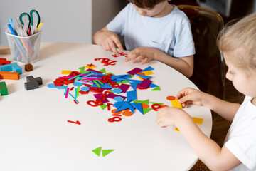 a girl at a round white table plays educational games, a house made of designer children's hands, the concept of development of preschoolers