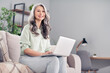 © deagreez - Photo portrait of elder woman sitting on sofa typing message on computer in social media