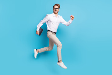 Sticker - Full body profile side photo of cheerful young happy man go empty space hold laptop isolated on blue color background