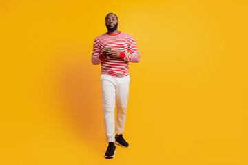 Wall Mural - Portrait of serious man hold telephone on yellow background